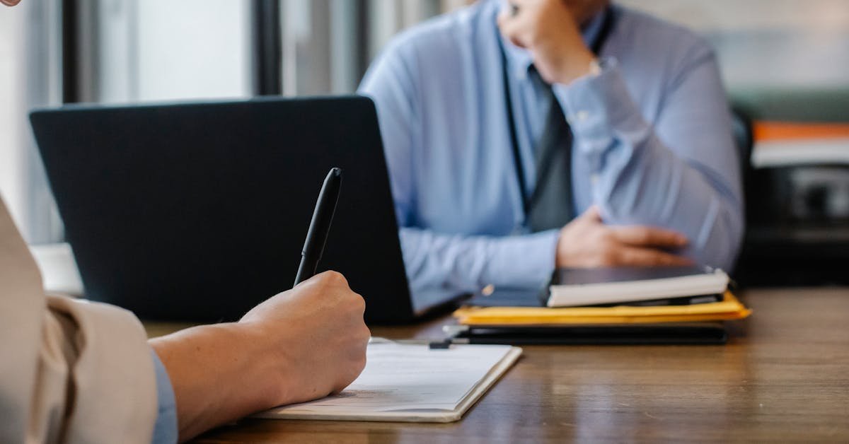 Professional carefully reviewing a commercial lease renewal document at a desk with a laptop and paperwork