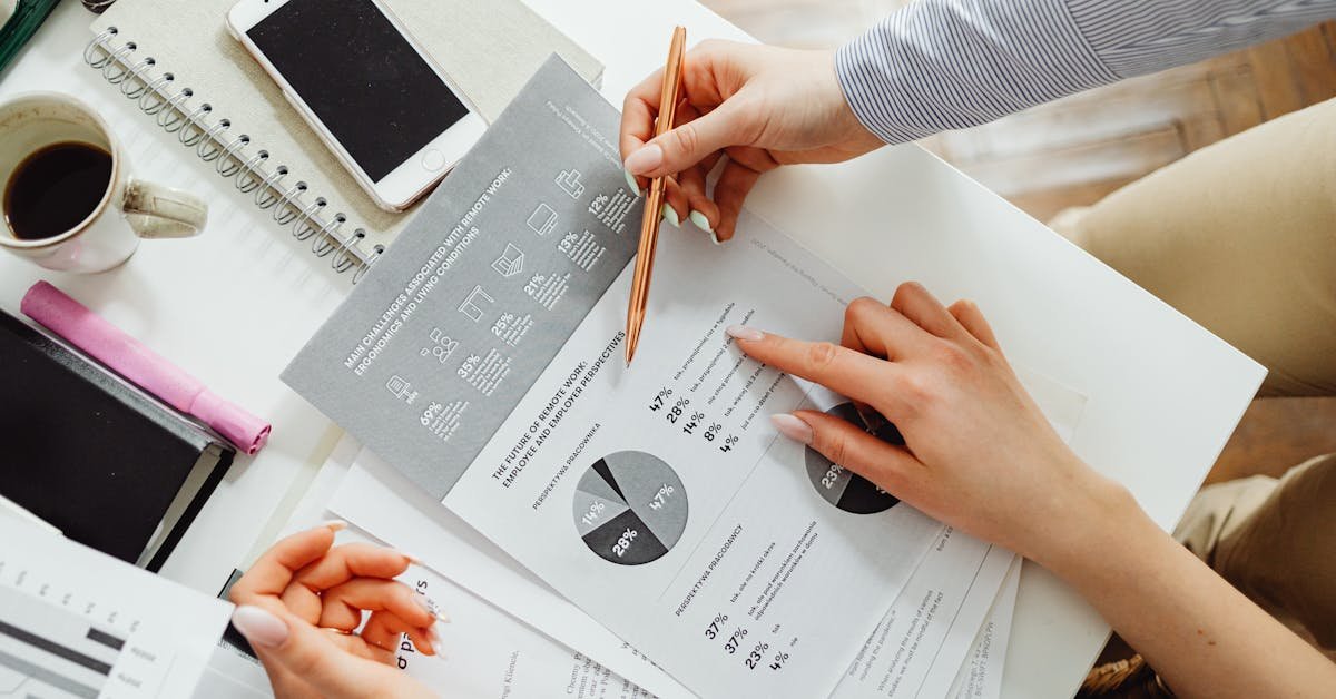 Professionals reviewing technical due diligence reports and property data charts at a desk
