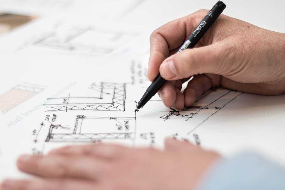 Close-up of a commercial building surveyor annotating technical construction drawings and plans during a commercial building survey