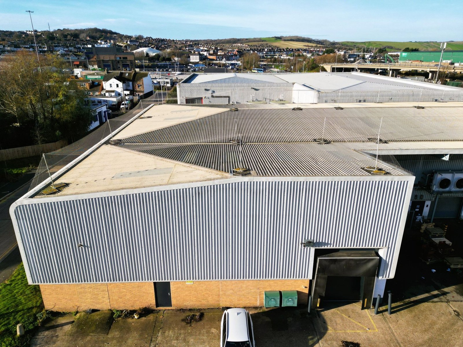 Aerial view of a large commercial building roof showing multiple sections and rooftop details during a building survey