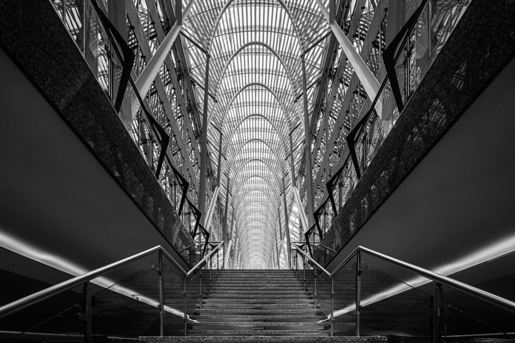 Dramatic architectural interior of a commercial building showing a vaulted glass-and-steel atrium